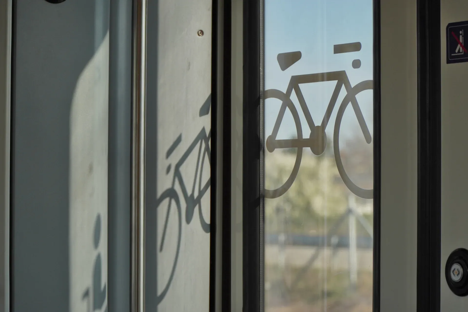 Symbol of a bicycle on the glass door of a train in Belgrade, Serbia, indicating bicycle transport.