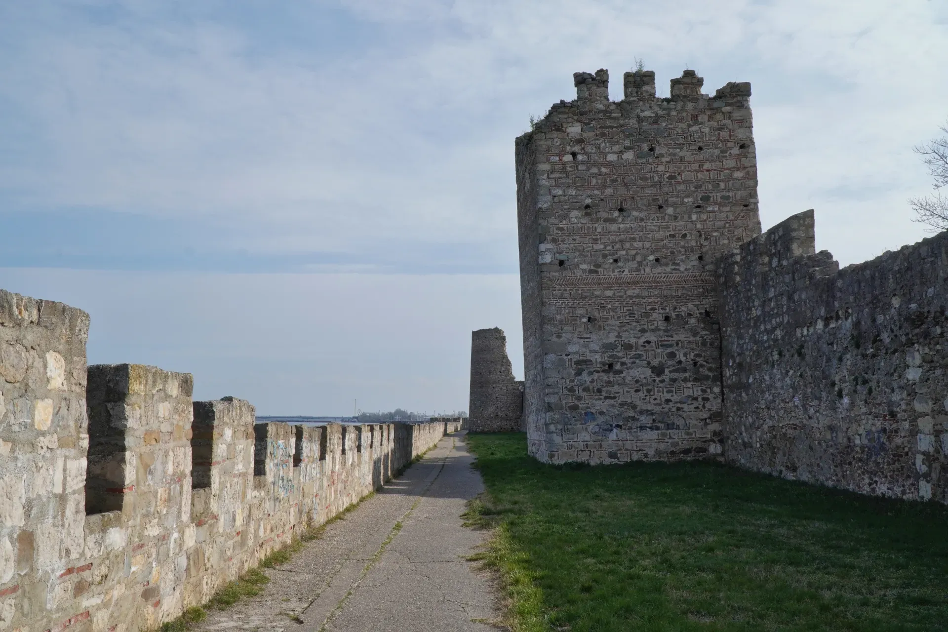 The stone walls and towers of Smederevo Fortress in Serbia, with a walkway winding along the wall.