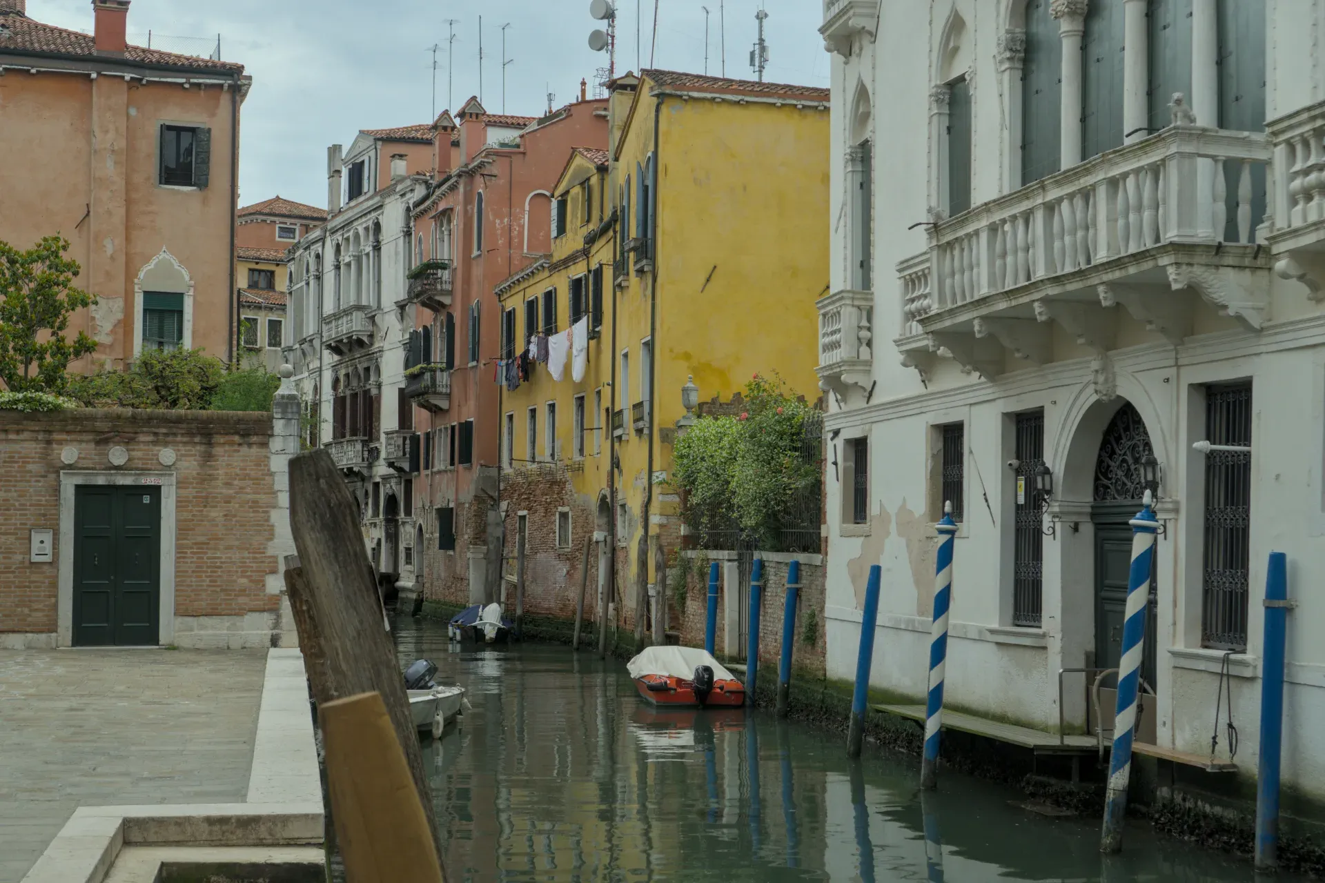 Un sereno canale veneziano con case tradizionali colorate e superfici d'acqua riflettenti.