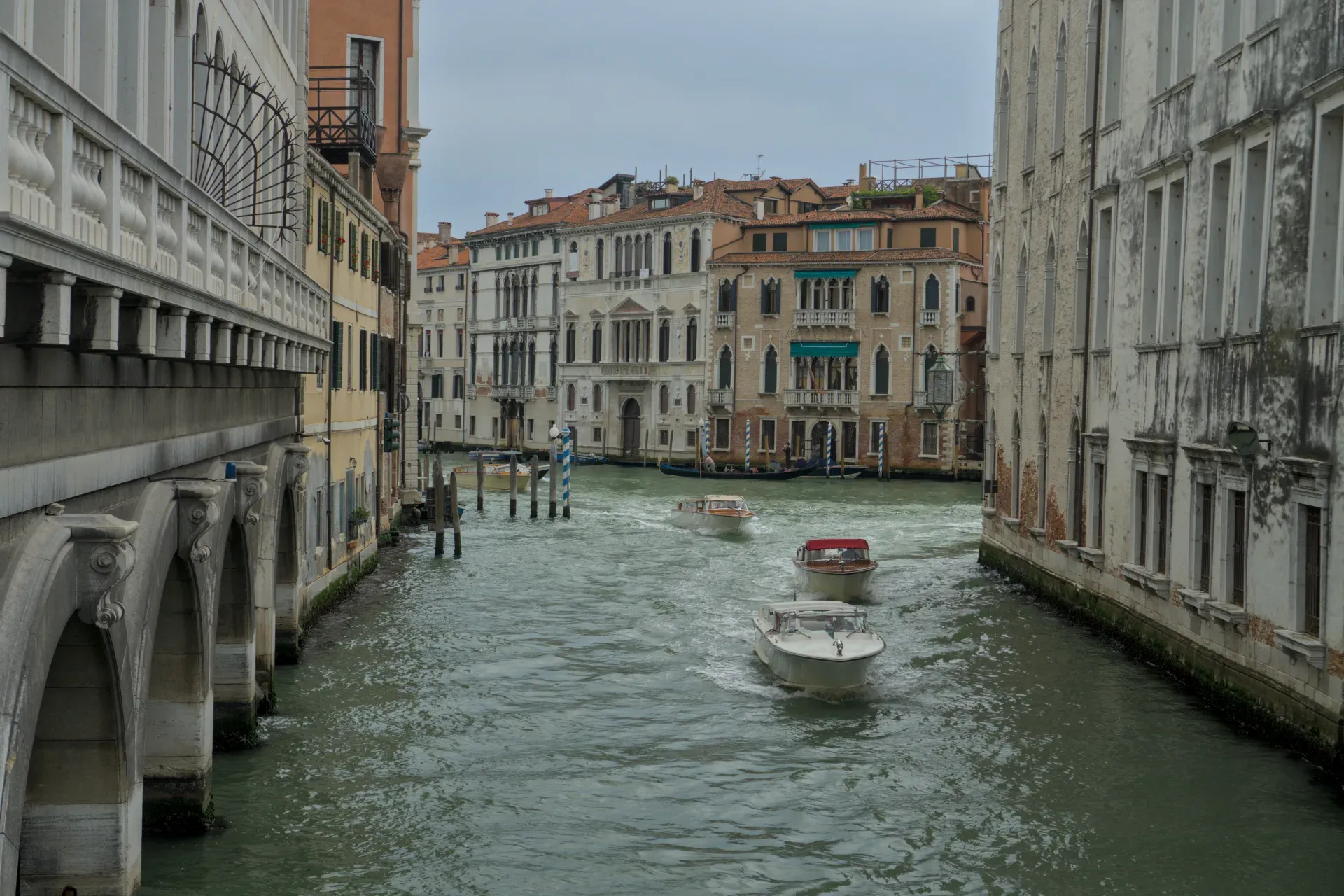 Barcos en el Gran Canal de Venecia, rodeados de edificios históricos y un puente.