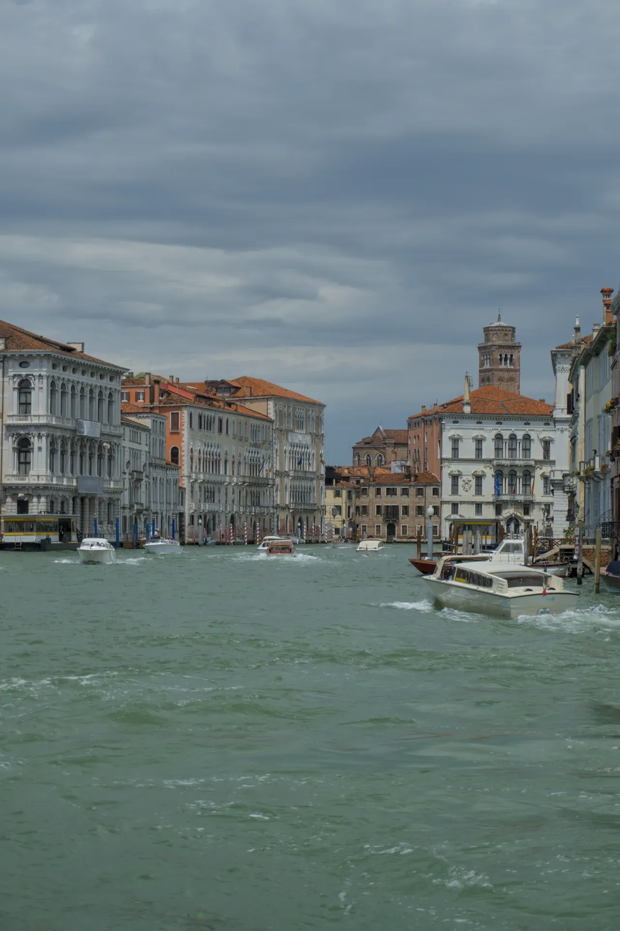 Kanale Grande u Veneciji sa istorijskim zgradama i čamcima pod dramatičnim nebom.