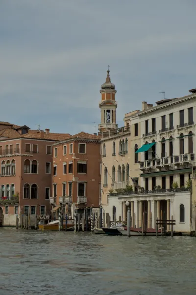 Fotografia di edifici sul Canal Grande a Venezia, Italia, con un campanile prominente e barche sull'acqua.