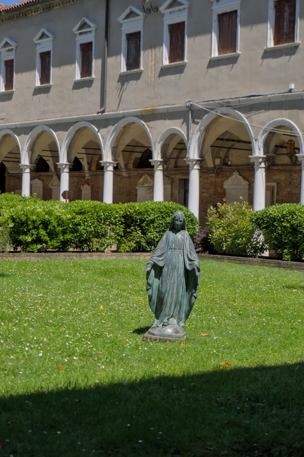 Estatua de bronce de la Madonna en el patio del Cementerio San Michele en Venecia.