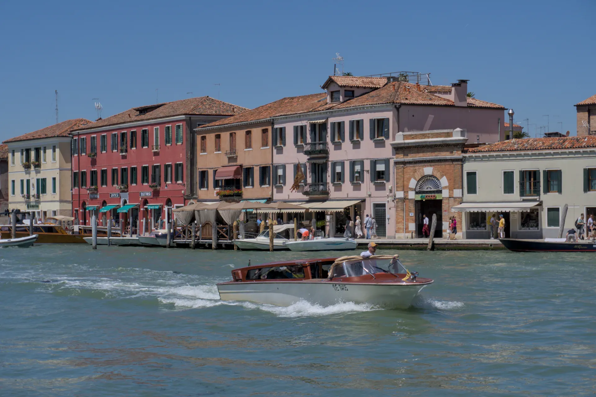Fotografia d'arte di canali sull'isola di Murano con edifici colorati e barche in formato orizzontale.