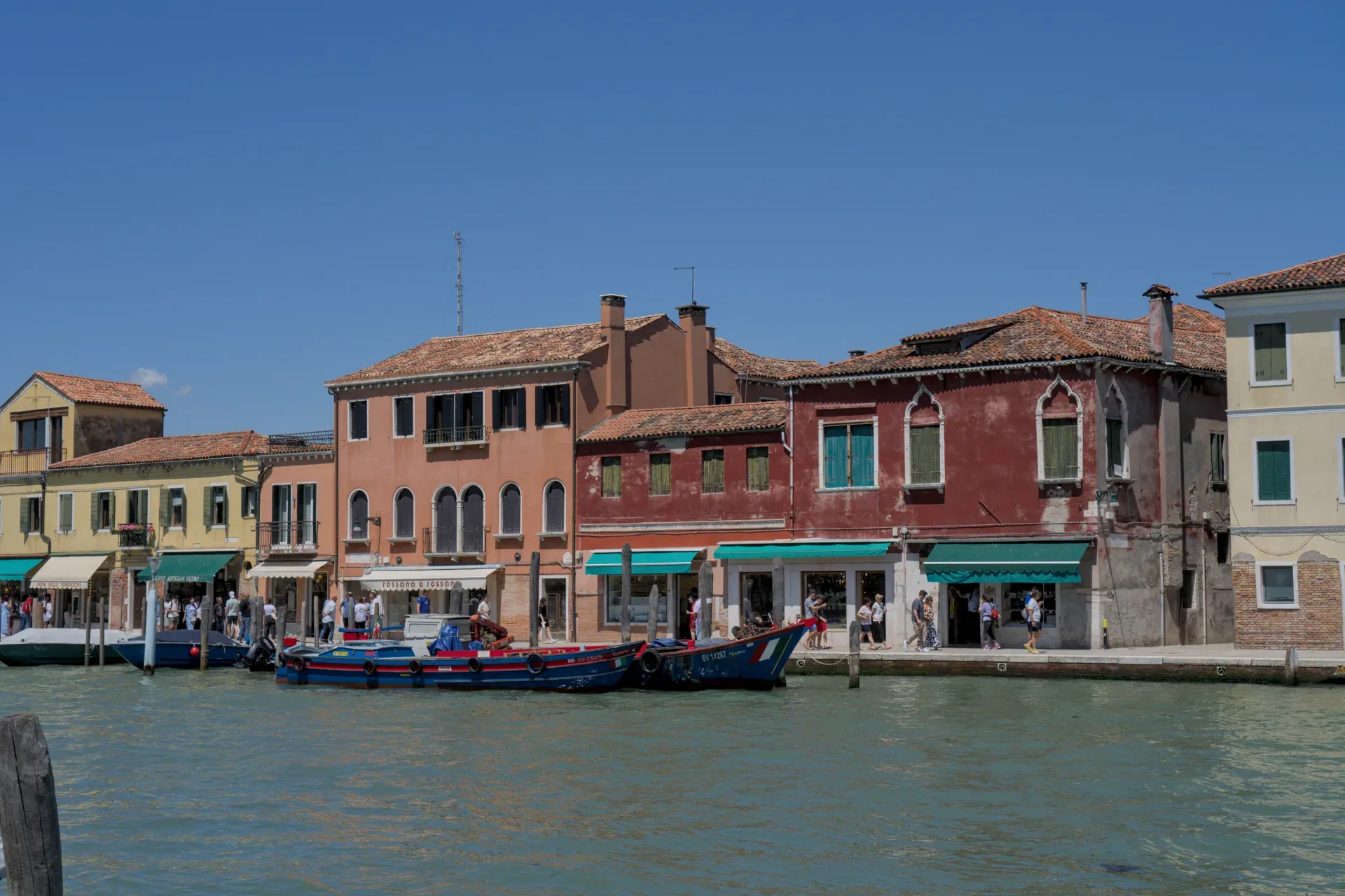 Edifici colorati e barche sull'acqua sull'isola di Murano, Italia.