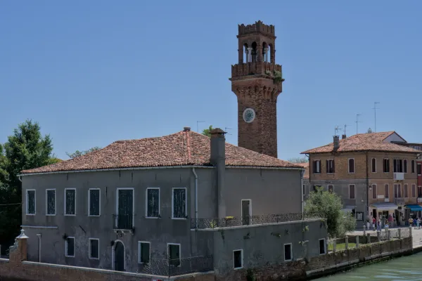 Uhrenturm auf Murano, Italien, mit antiken Gebäuden und ruhigem Wasser.