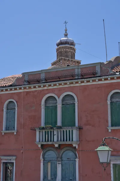Fenster und Kuppel auf Murano, einer Insel in Venedig, Italien, mit typischer Architektur und grünen Fensterläden.