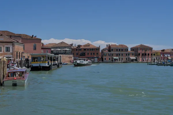 Der Kanal auf Murano, Italien, mit Wasser, Booten und Häusern im Hintergrund.