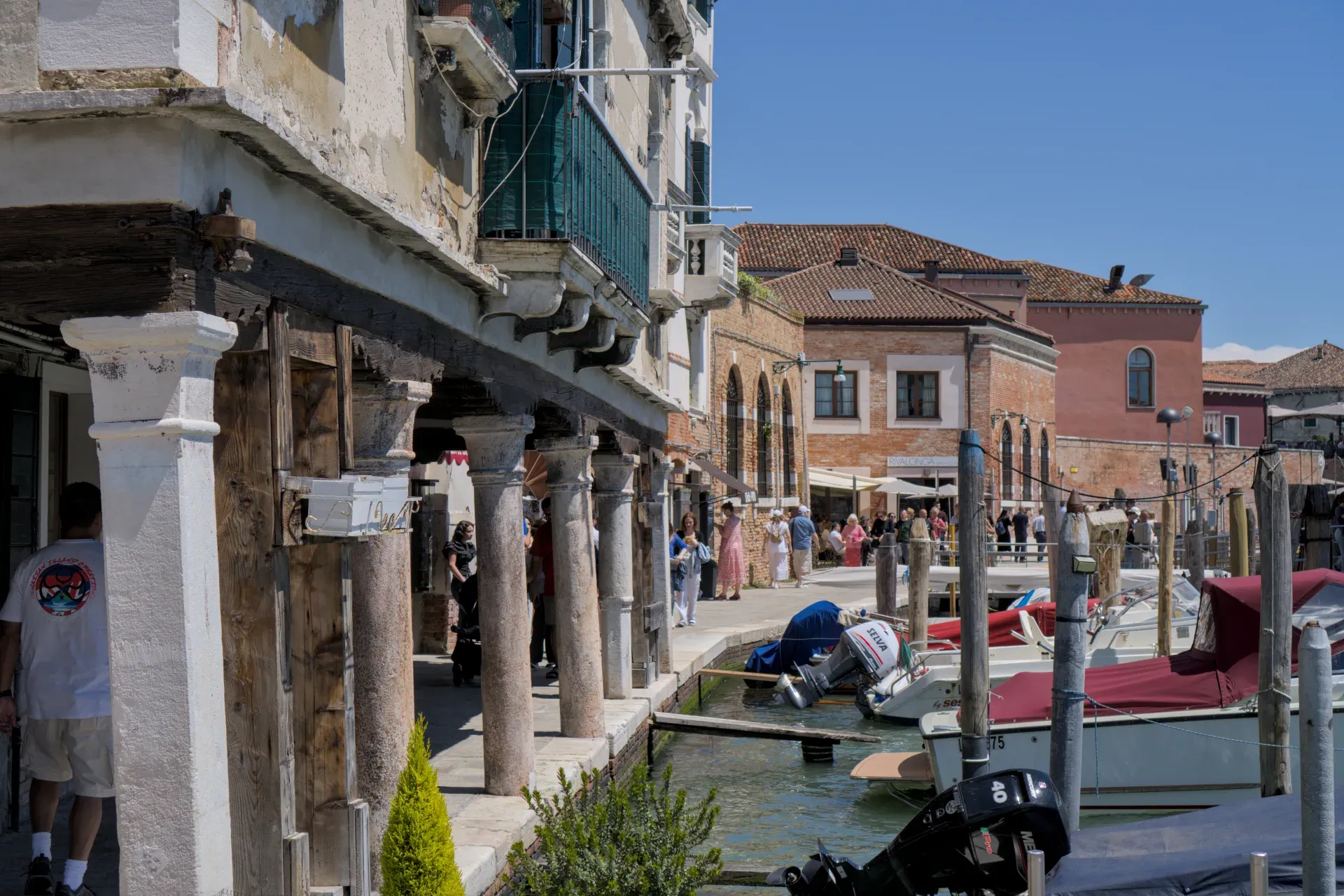 Vista del canal de la isla de Murano en Venecia con barcos y edificios tradicionales.