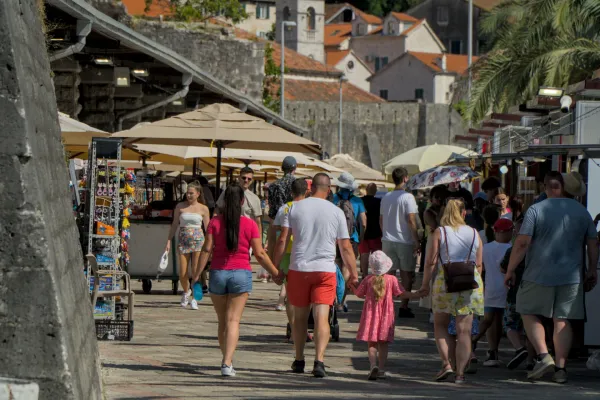 People walking past market stalls in Kotor, Montenegro, near the old town.