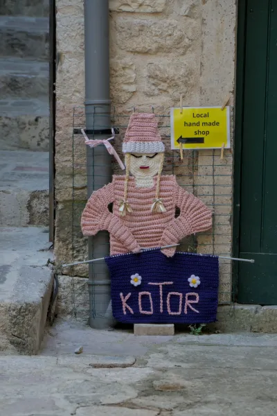 Handmade knitted sign reading 'Kotor' and 'Local hand made shop' in Montenegro.