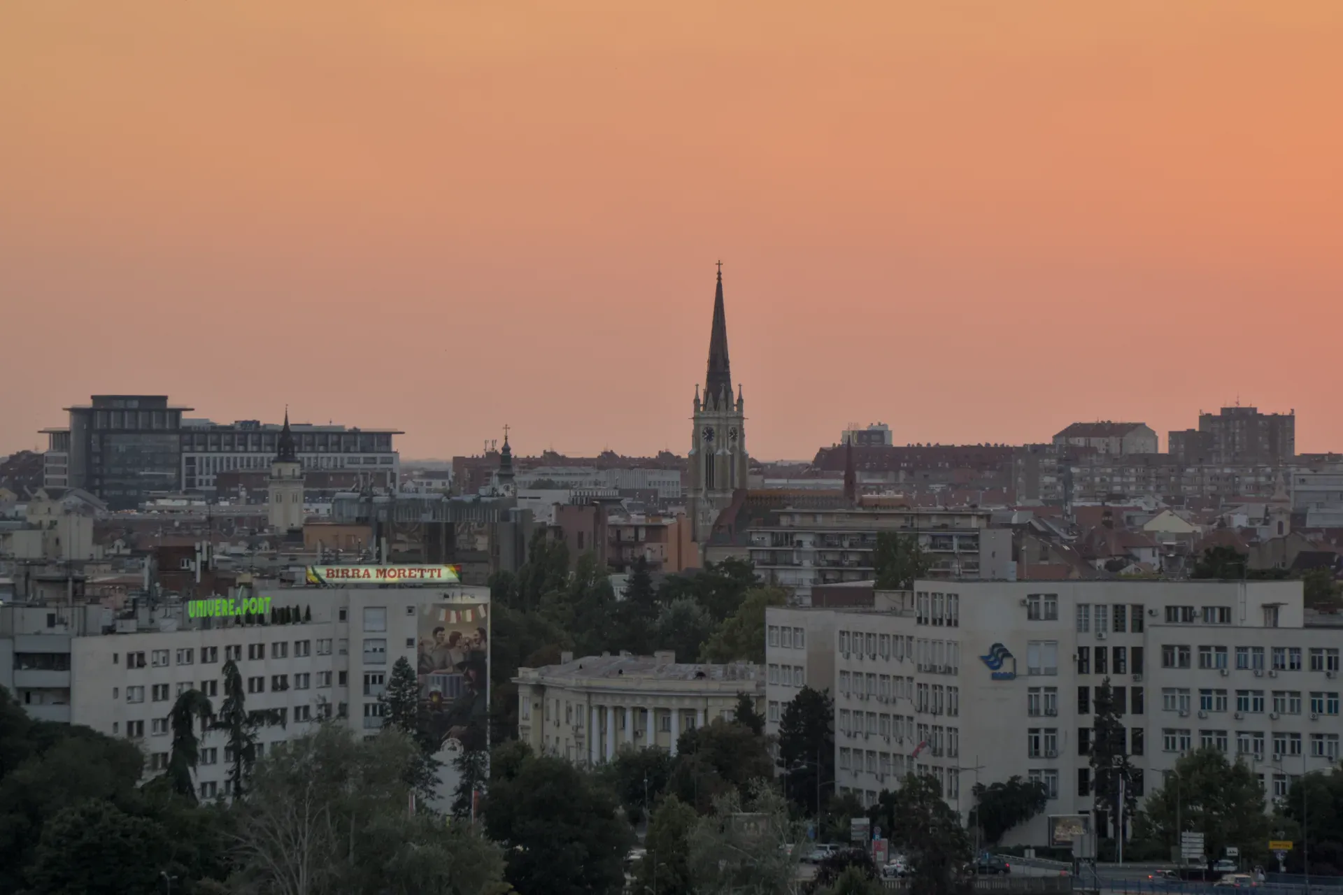 Panorama Novog Sada u suton, viđena sa Petrovaradinske tvrđave, sa crkvenim tornjevima i gradskim pejzažem.