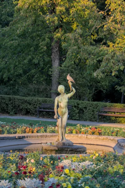 Sculpture of a girl with a cornucopia, on which a bird is perched, in a park in Novi Sad, Serbia.