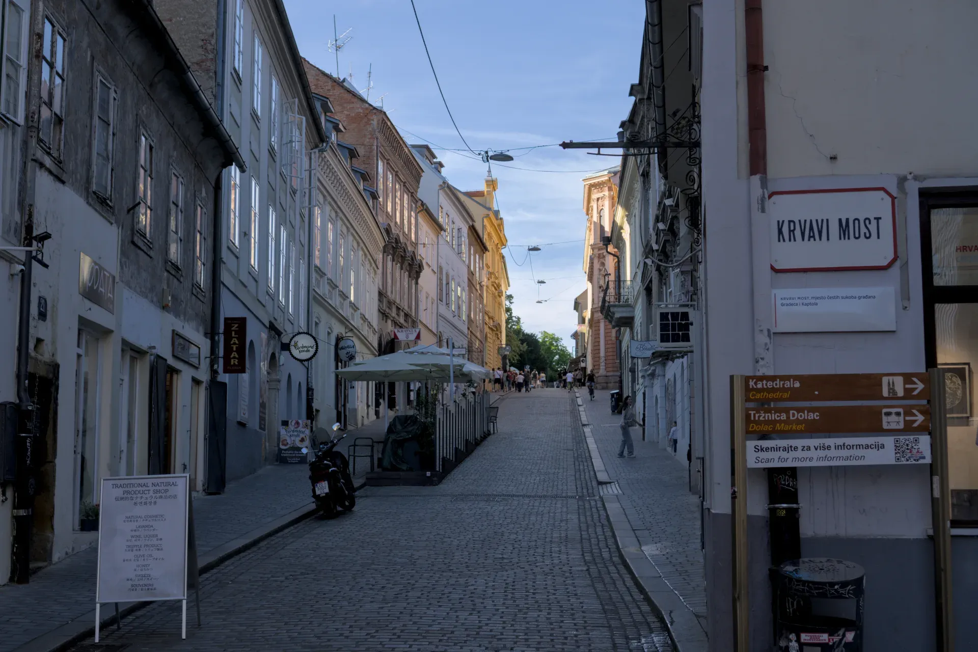 Zagrebačka kaldrmisana ulica sa istorijskim zgradama i večernjim osvetljenjem.