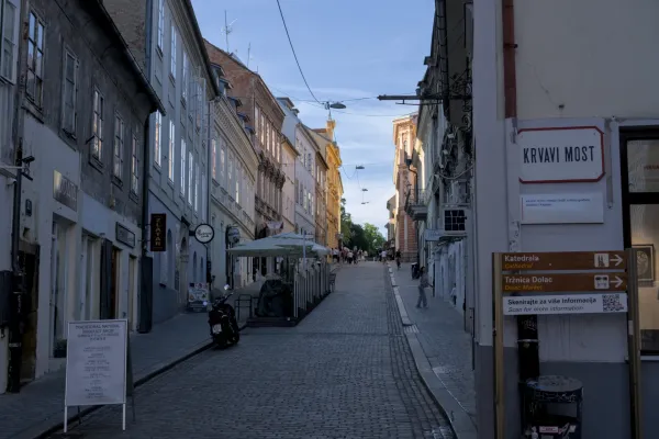 Eine Kopfsteinpflastergasse in Zagreb mit historischen Gebäuden und abendlicher Beleuchtung.