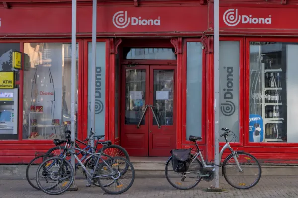 Eine lebendige rote Fassade eines Geschäfts in Zagreb, mit mehreren Fahrrädern davor geparkt, aufgenommen im Querformat.