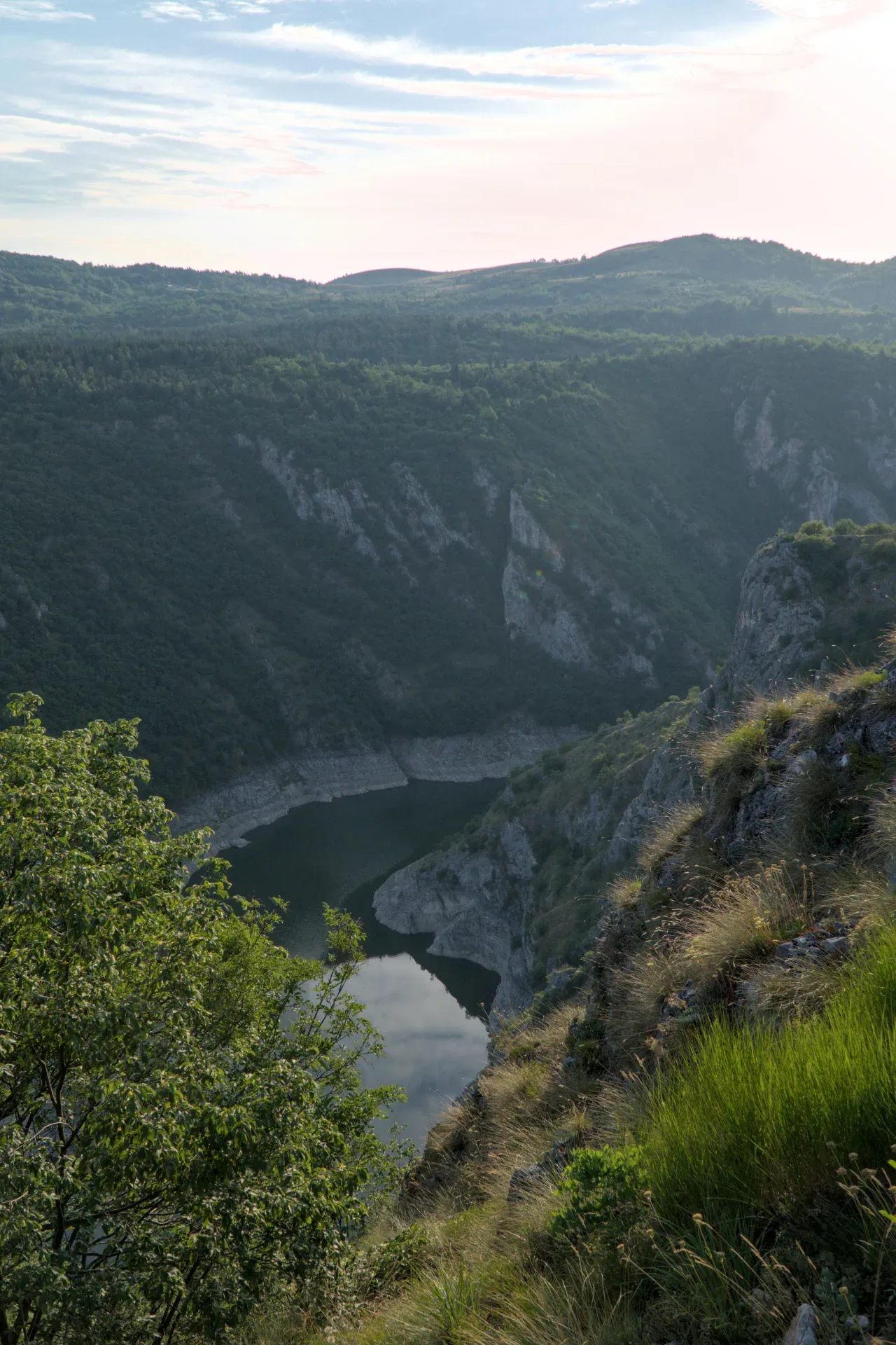 Los cañones de Uvac al atardecer con un río tranquilo y montañas.