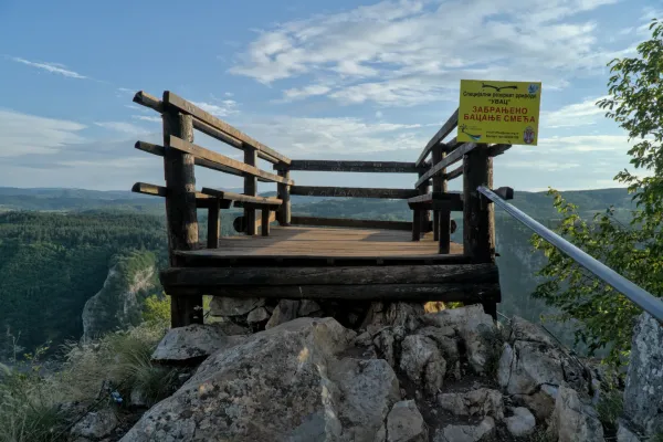 The wooden "Prayer" viewpoint overlooks the lush Uvac Canyon in Serbia during daylight.