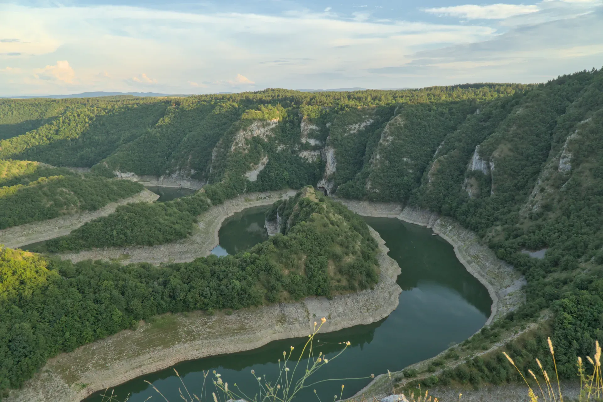 Landscape photography of the Uvac meanders in Serbia, featuring lush green hills and a winding river.