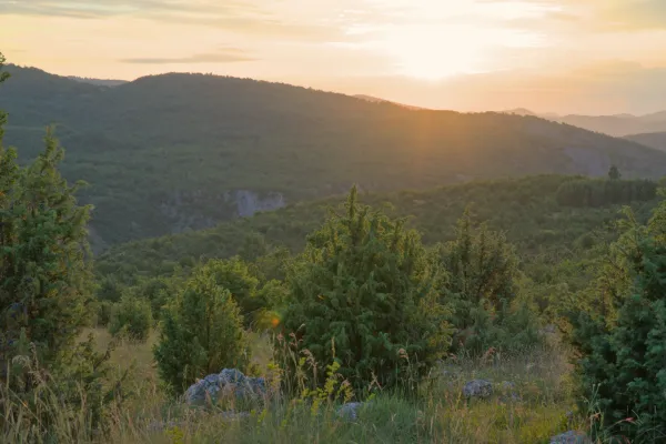 Sunset on the "Molitva" elevation in Uvac, Serbia, with gentle hills and warm light.