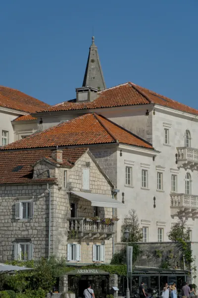 The waterfront of Perast at sunset with characteristic roofs and buildings.