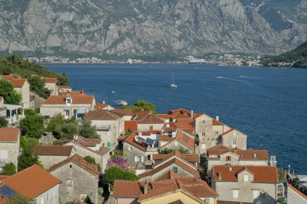 Panoramic view from the bell tower of Perast over the Bay of Kotor with houses and mountains.