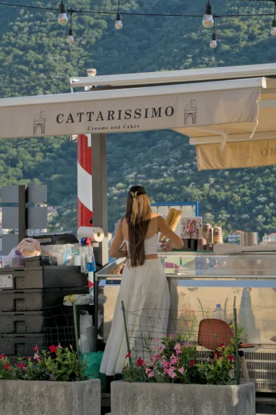 A gelateria in Perast, Montenegro, with a female vendor in summer.