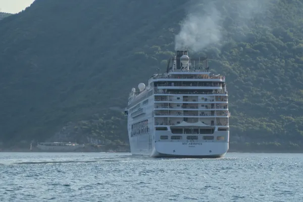 A large cruise ship, the MSC Armonia, steams away from the Bay of Kotor, Montenegro.