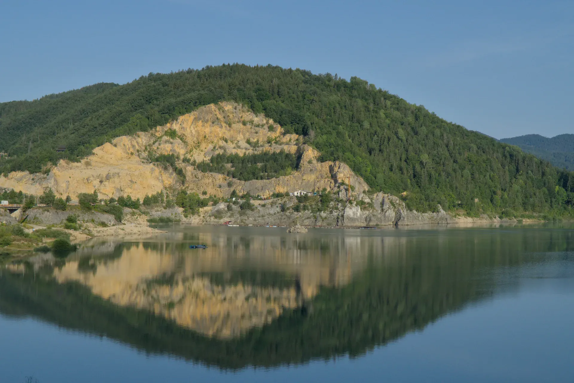 Morning view of Zaovine Lake in Tara National Park, featuring reflective mountains and forests, perfect for galleries.