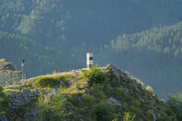 A striking black and white pillar stands sentinel on a rocky outcrop at Lazic Dam on Zaovine Lake, Serbia.