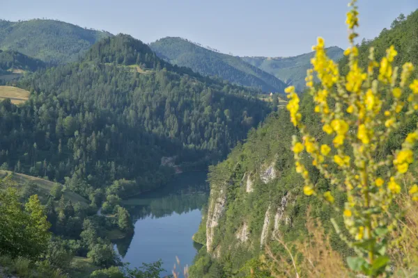 Spaiic Lake, Serbia, surrounded by rocky cliffs and green mountain meadows.