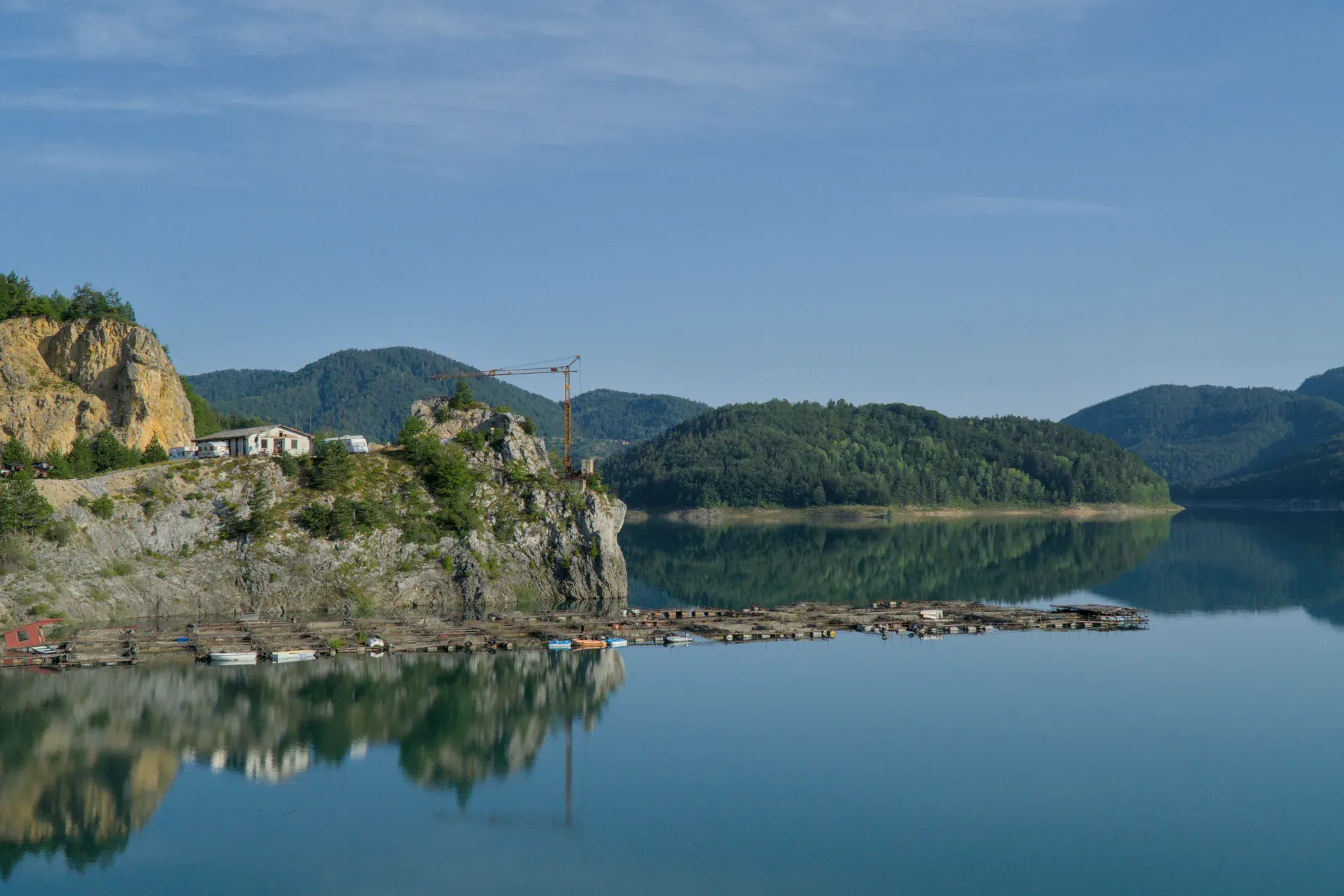 Morning idyll at Zaovine Lake in Tara National Park, Serbia, with calm waters and forested hills.