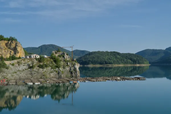 Morning idyll at Zaovine Lake in Tara National Park, Serbia, with calm waters and forested hills.