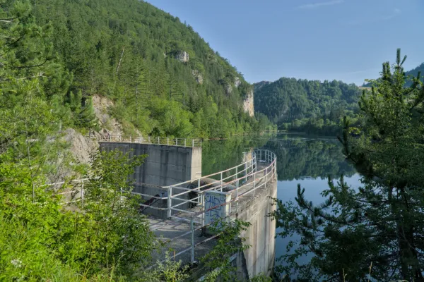 Lypovica dam in Zaovine, Tara National Park, Serbia, with green mountains in the background and reflections on the water.