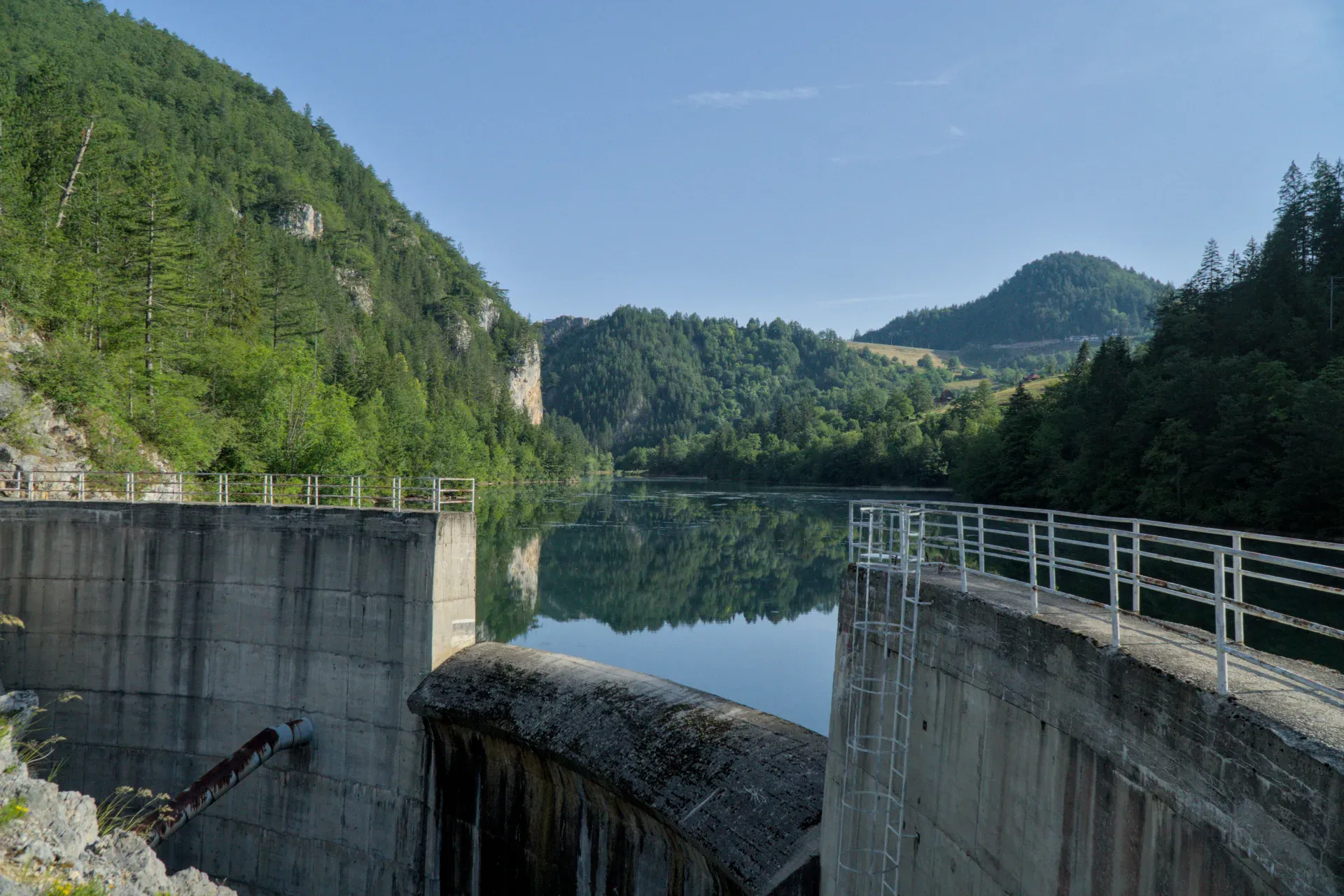 The Spajići Dam in Zaovine, Serbia, with a mountainous backdrop and reflective water, perfect for gallery art.