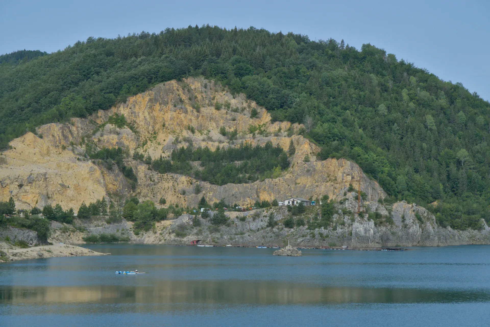 Morning over Zaovine Lake in Tara National Park, Serbia, featuring rugged cliffs and lush green forests.