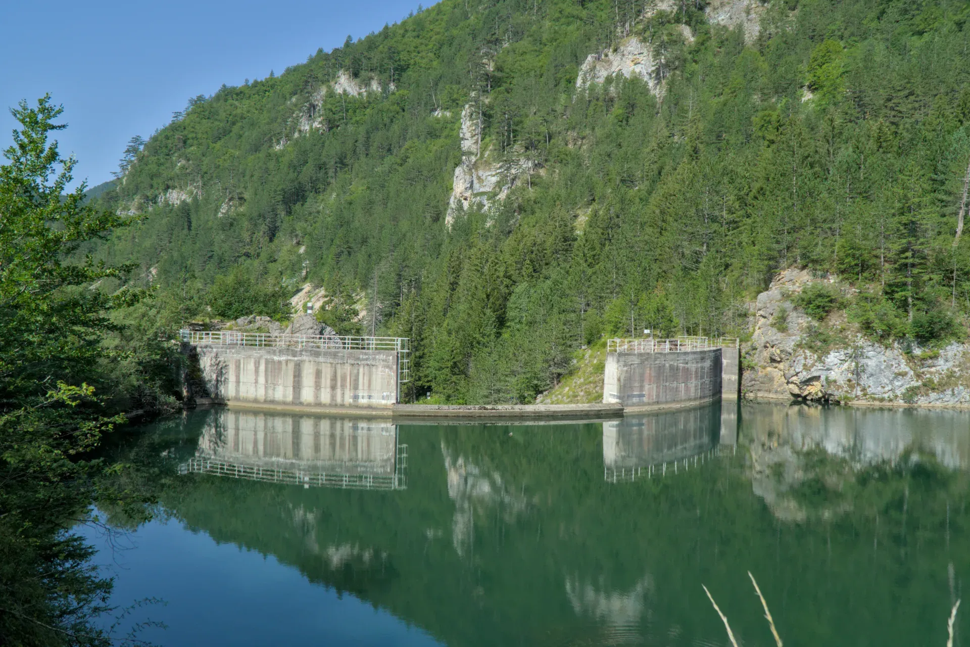 Spajići Dam at Zaovine, surrounded by green mountains with reflections in the water.