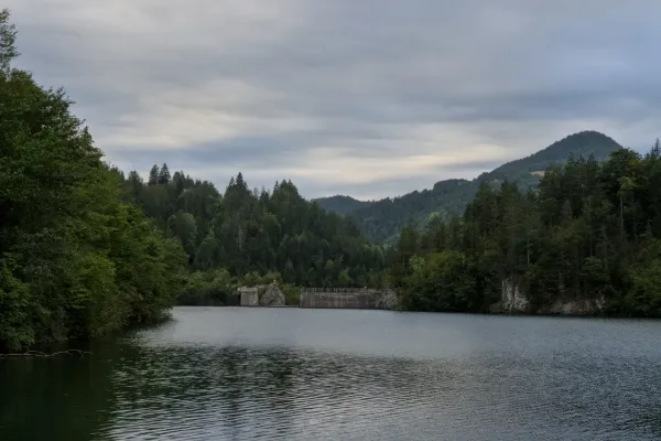 A dam on Spajići Lake in Tara National Park, Serbia, with forested hills in the background.
