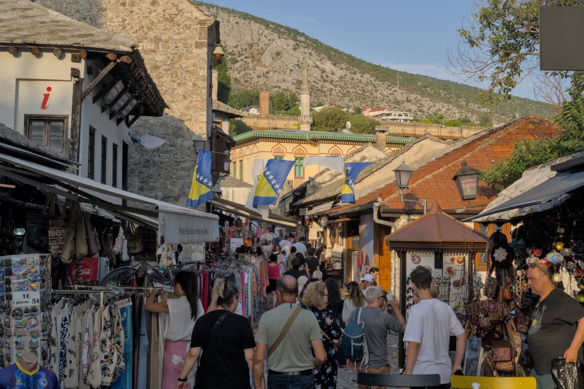 Evening light in Mostar's historic old town, featuring bustling streets and traditional architecture.