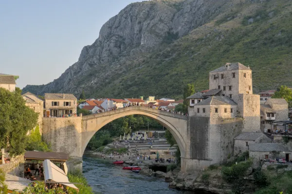 The Old Bridge of Mostar at sunset, showcasing historic architecture and the Neretva River.