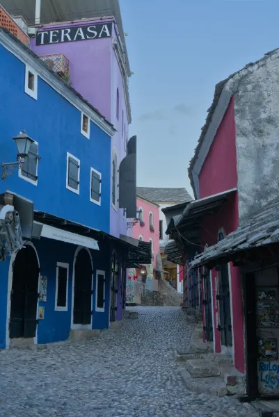 Mostar Old Town street in early morning with colorful buildings and cobblestones.