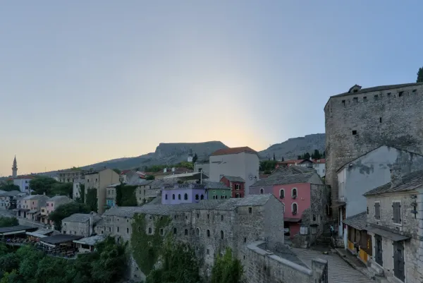Mostar's historic Old Town awakens in the morning light, "старый город просыпается", showcasing traditional stone buildings.