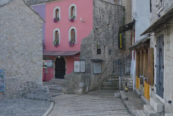 Empty streets in old Mostar early morning with pink and stone buildings.