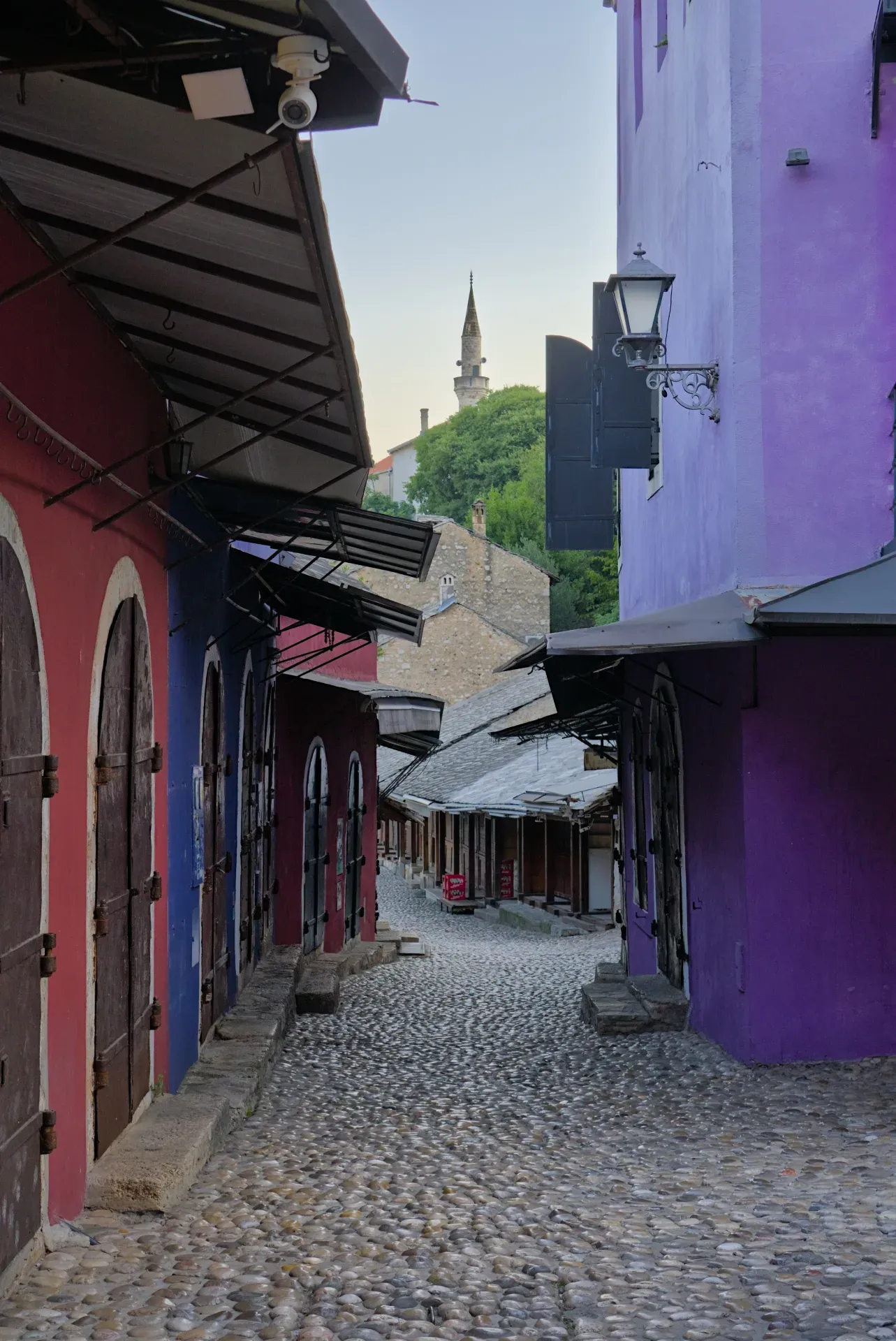 Early morning in Mostar's old town, showcasing vibrant facades and a cobblestone path.