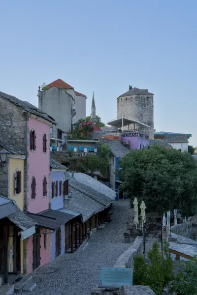Sunrise over Mostar's historic old town in Bosnia and Herzegovina, featuring colorful buildings and cobblestone streets.