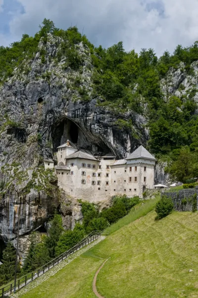 Predjama Castle, 'Predjamski grad', is built into a cliff face in Postojna, Slovenia, presenting a striking architectural feat.