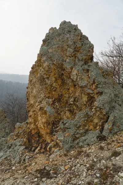 Orlov Rocks formation in Fruska Gora, Serbia, during late winter, with a backdrop of trees and sky.