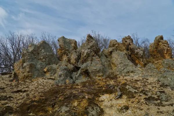 Orlovo Stijene (Eagle Rocks) in Fruška Gora, Serbia, featuring dramatic rock formations and bare trees in the background.