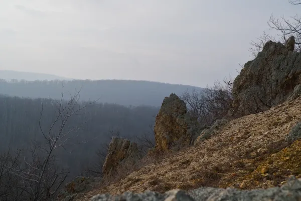 The "Orlove Stene" on Fruska Gora, Serbia, featuring rocky terrain and forested hills in the distance.