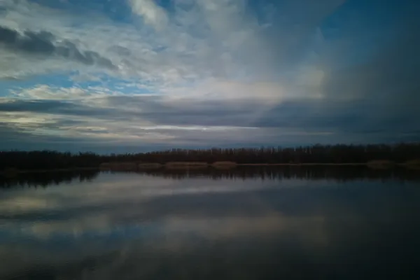 Landscape fine art photo of Begečka Jama in Serbia, showcasing a dramatic sky and water reflection.